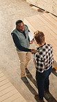 Carpenter, meeting and happy man with handshake in warehouse for wood production or agreement. Top view, male people or employees shaking hands with deal for timber or lumber distribution in workshop
