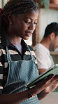 Reading, woman and waitress with tablet in cafe with research, inventory or online menu update. Server, digital technology and barista in coffee shop for order on app, website or customer service.