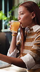 Orange juice, relax and thinking with woman in cafe for antioxidant drink, hospitality and gut health. Vision, organic liquid and detox with person and glass in coffee shop for beverage and vegan