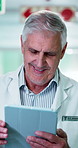 Tablet, man and doctor in hospital for research on medical diagnosis or treatment planning. Digital technology, reading and mature healthcare worker with telehealth service on app in clinic hallway.