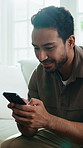 Relax, phone and happy man on sofa for typing, social media forum and internet search on weekend. Mobile, smile and person in home living room with chat app, communication and contact feedback
