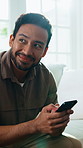 Relax, phone and happy man in home for thinking, social media forum and typing text on weekend. Mobile, smile and person on living room sofa with chat app, communication and message feedback idea