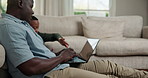 Laptop, remote work and dad with child in lounge, copywriting and explaining project to son in home. Creative, freelancer and black man with tech for article, family and discussion with kid in house