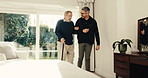 Caregiver, help and old person with walking stick in home for support, assistance or physical therapy. Man, senior patient with a disability or cane in assisted living facility for physio or recovery