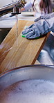 Hands, person and washing dishes in kitchen for hygiene, bacteria safety and housekeeping routine. Parent, sponge and chopping board with foam for cleaning service, germ protection or chores in home