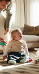 Baby boy, crying and father with toy for comfort or consoling on floor of home living room. Distraction, sad and tears of infant child in apartment with single parent man for care or development