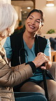 Happy, old woman and nurse talk in homecare for stroke recovery, wellness checkup or compassion. Laugh, caregiver or senior person with cane for mobility progress, medical support or assisted living