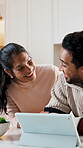 Couple, online and laughing with tablet in kitchen, good news or debt payoff notification on website. Check, credit score and happy people with tech, love and financial planning with partner in house