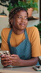 Thinking, laugh and barista in cafe with phone, chat response and funny memory on work break. Texting, happy or black woman with joke nostalgia, hospitality meme or online communication in free time.