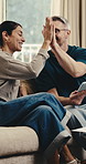 Mature, tablet and happy couple with high five in home for finance, budget success or investment. Excited, man and woman with smile or technology on sofa for financial achievement or profit in house