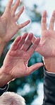 People, sunlight and community with hands raised in nature for interaction or participation. Group, friends or senior team with arm up for outdoor engagement, social inclusion or effort together