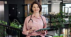 Face, woman and happy doctor with tablet for healthcare career, experience and confidence in clinic. Tech, mature person and medical worker in hospital with smile, telehealth support and portrait