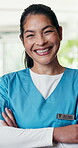 Face, smile and medical doctor at clinic for healthcare service, confident and wellness with pride. Portrait, happy and person with uniform in hospital for medicine, support and arms crossed or laugh