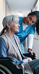 Wheelchair, nurse or old woman in hospital for healthcare, talking or rehabilitation help. Medical worker, retirement and person with disability, smile or assistance for recovery support in hallway
