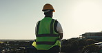 Thinking, hardhat and back of construction worker on site for inspection of building, repairs or renovation. Helmet, man and civil engineer planning or ideas for property development or remodeling.