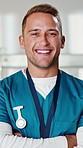 Face, nurse and healthcare with smile at hospital, medical professional and integrity in surgery. Man, health worker or surgical assistant with ambition, pride in medicine and happy with arms crossed