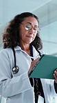 Doctor, online and woman with tablet in hospital, research and reading healthcare report on website. Clinic, medical professional and mature person with technology, scroll and treatment plan on app