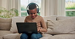 Laptop, headphones and black child on sofa in home for elearning, network or online streaming. Boy, kid or interaction with computer for web tutorial, childhood development or connection in house
