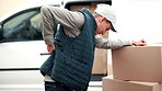 Logistics, box and man with back pain, delivery issue and spine injury in outdoor distribution. Strain, burnout and courier at van with packages, backache massage or muscle discomfort in supply chain