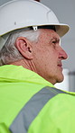 Back, thinking and man with helmet for construction, renovation project and remodeling in building. Safety, supervisor and mature person with ppe for property inspection, compliance and architecture