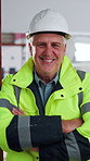 Laugh, face and man with helmet for construction, renovation project and remodeling in building. Mature, portrait and person with ppe, safety and crossed arms for contractor, property or architecture
