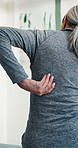 Physiotherapy, back pain and senior woman in clinic for consulting, osteoarthritis and recovery. Healthcare, office and elderly person with arthritis for physical therapy, wellness and appointment
