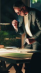 Excited, architect and man with blueprint in office, smile or review floor plan for design at night. Happy, designer and mature person with documents, working late and fist pump for achievement
