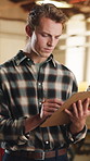 Writing, carpenter and man with clipboard in warehouse for inspection, planning or agenda. Manufacturing, timber factory and person with checklist for workshop, safety and compliance with stock