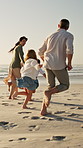 Parents, children and running at beach with race on vacation, play and bonding for love in summer. Happy people, laugh and girl kids with fun, excited and holding hands with games on family holiday