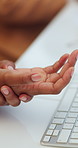 Woman, typing and hand pain in office with computer, massage and carpal tunnel symptoms from fatigue. Desktop, tired female person and joint injury in business with arthritis, burnout and overworked.