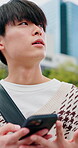 Phone, sightseeing and thinking with Asian man in city to search for directions on digital map. App, happy and navigation with thoughtful person outdoor for holiday, travel or vacation planning