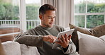 Man, relax and research with tablet on sofa for network, online connection or streaming in home. Male person, scrolling or user with smile on technology for social media, internet or app in house