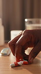 Home, health and hands of woman with pills for treatment, antibiotics and medicine for recovery. Healthcare, table and person with medication, tablets and capsule for prescription, wellness and cure
