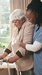 Senior, woman and nurse with walker for assisted living, physiotherapy or balance in practice. Female person, caregiver or helping elderly patient with support for walking, mobility or recovery