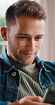 Phone, relax and happy man in home for typing, social media or communication for online dating. Mobile, chill and male person on living room sofa for chat app, text message or smile for love interest