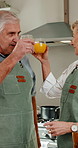 Cooking, cheers and old couple in kitchen with juice, bonding together or laugh for funny discussion. Happy, married senior people and toast in home with drink, healthy diet and retirement wellness.
