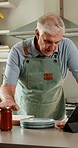 Cooking, food and old man in kitchen with tablet, watch online video and healthy diet for retirement. Senior person, reading and meal prep in home with tech, ingredients or tutorial for lunch recipe.