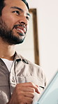 Smile, thinking and man with tablet in home with research, communication or reading blog on app. Happy, digital technology and person with online article on budget planning in house from below.