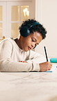 Homework, headphones and child in home with notebook, learning and concentration for studying. House, student and boy with audio, online lesson and assignment for education, development and knowledge