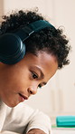 Homework, headphones and child in home for writing answer, learning and focus for studying. House, student and boy with audio, online lesson and assignment for education, development and knowledge