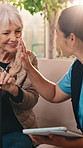 Caregiver, high five and senior woman with support for wellness, medical healthcare and tablet. Smile, nurse and person with cane for retirement, tech and checkup success in homecare with celebration