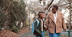 Mom, walk and holding hands in neighborhood with school child, story or discussion for education. Happy, black woman and conversation outdoor with son, afternoon commute or talk about day at academy.