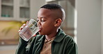 Health, kid and drinking water in home for wellness, nutrition benefits and development for growth. Thirsty black boy, hydration and glass with beverage for diet, minerals and refreshment at kitchen