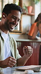 Man, laptop and fist pump in restaurant with video call, earphones and achievement for remote work. Happy freelancer, person and celebration in cafe with computer, online meeting and project success.