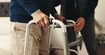 Caregiver, hands and senior person with walker in home for support, assistance or physical therapy. Man, old patient with a disability and frame in assisted living facility for physio and recovery