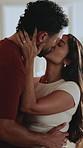 Love, hug and couple in house with kiss, partner connection and commitment in healthy relationship. Happy, affection and people in home with smile, security and tender embrace in romantic moment.
