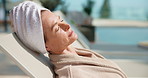Woman, relax and sleeping in luxury resort for holiday getaway, weekend or break by swimming pool. Female person, asleep and rest with towel for vitamin D, stress relief or vacation in beauty spa