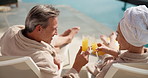 Relax, drink and couple by pool at hotel for vacation, holiday and bonding on weekend getaway. Marriage, toast and man with woman cheers with mimosa, alcohol and juice for love, break and travel