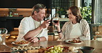 Couple, cheers and eating with wine glass for romantic date, dinner or meal together in home. Man, woman or toast with alcohol, food or drink for honeymoon celebration, event or holiday in house