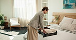 Clothes, suitcase and woman packing in hotel for travel, accommodation and check out in room. Hospitality, lodge and person with clothing, luggage and bag for business trip, reservation or booking